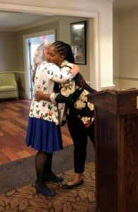 Nora Gillespie and Bryanna Rhodes hug during remarks at the July apprenticeship graduation ceremony.