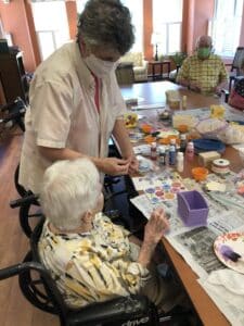 Martha Dodson does a craft with a resident at The Huntington