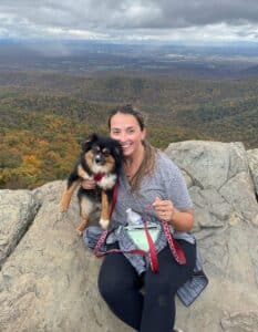 Coliseum Activity Director Haley Holland pictured on a mountaintop with her dog Millie.