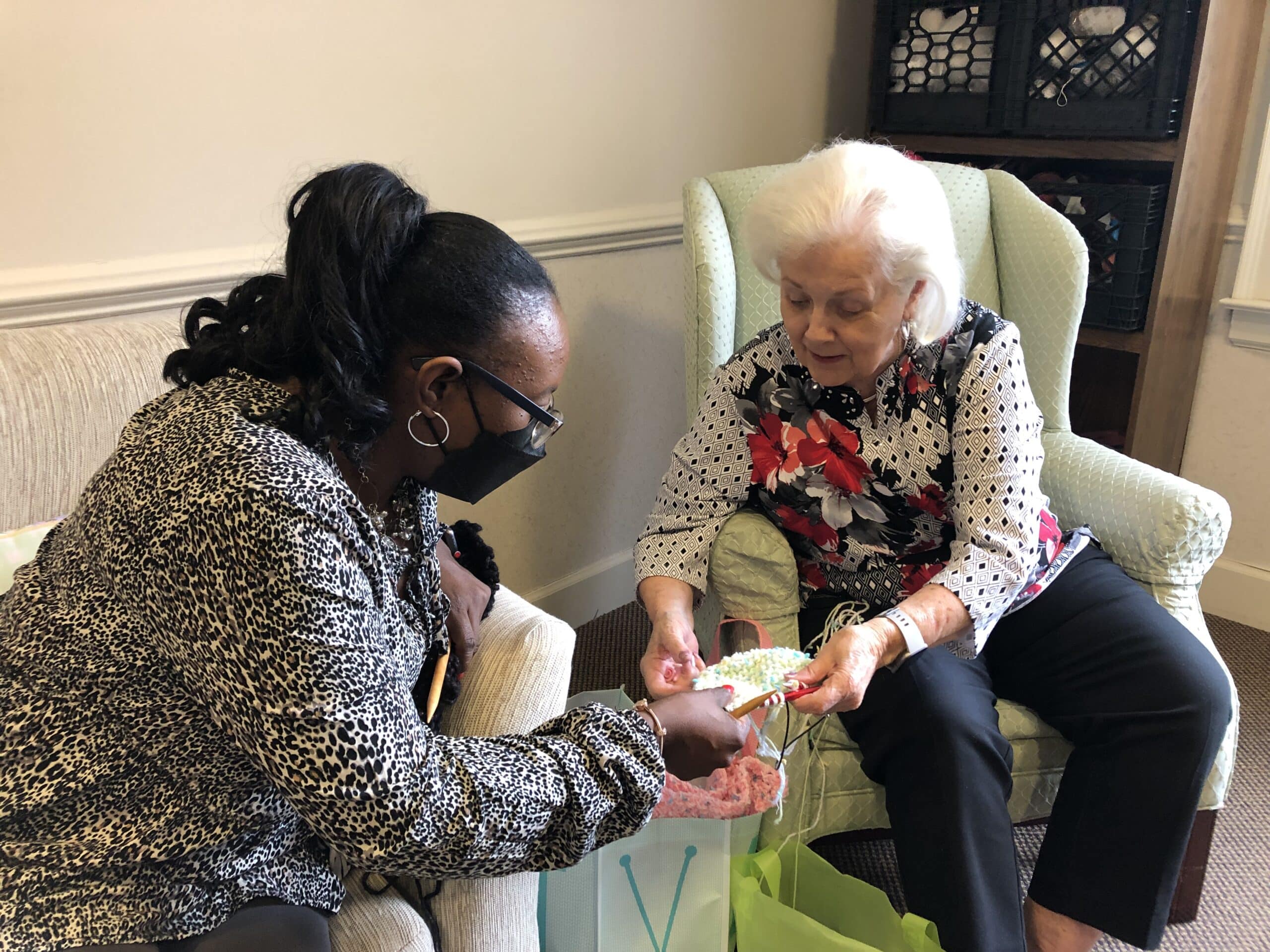 Arbors activity director Ora Williams is learning how to knit with the residents, led by Joyce.