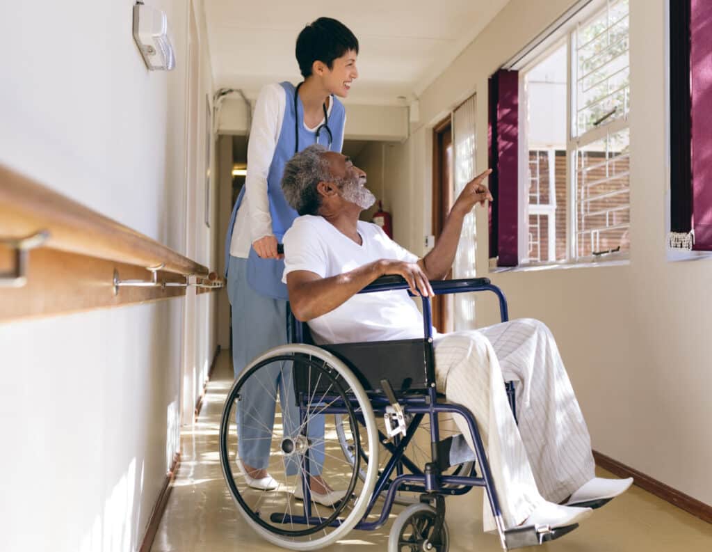 Nurse pushes elderly gentleman in wheelchair