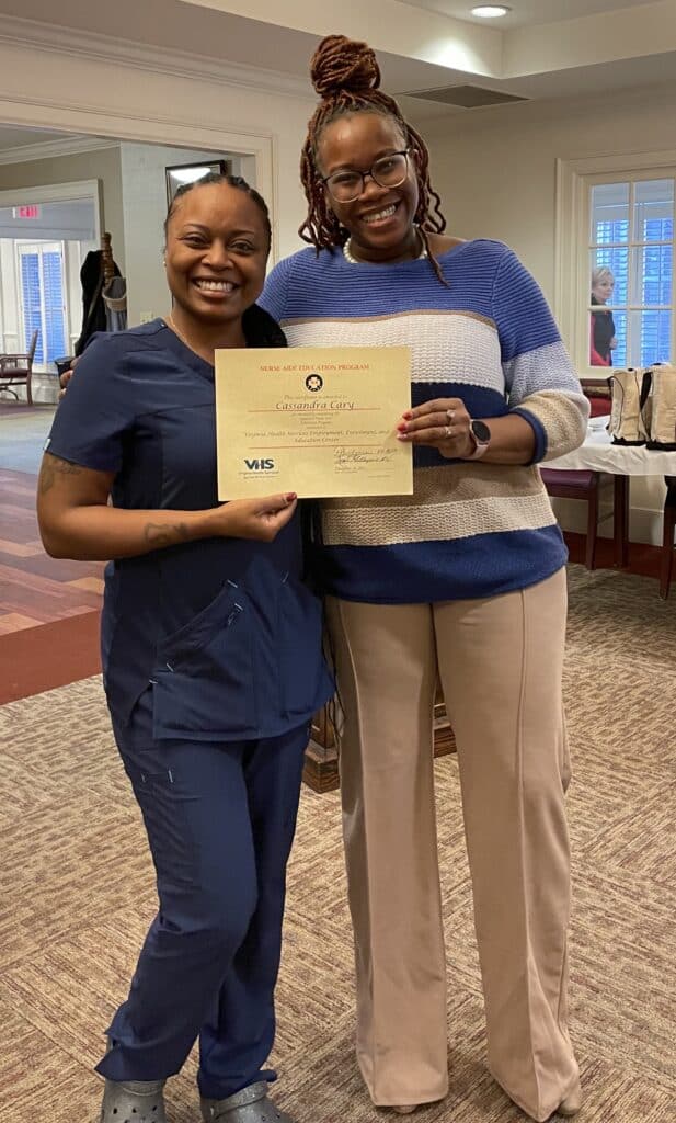 Graduate Cassandra Cary holding her certificate with instructor Princess Henderson.