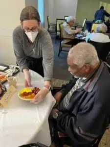 Ella serves a Resident at The Hamilton breakfast.