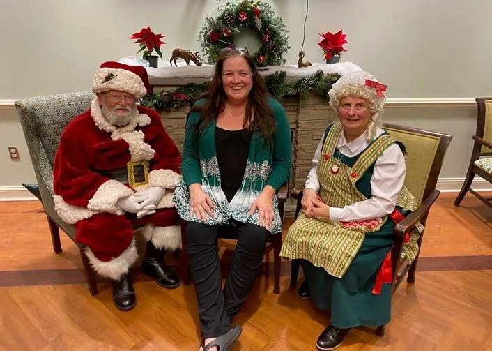 Huntington Activity Director Bonnie Fitz with volunteers Jerry and Martha Dodson at a holiday event.