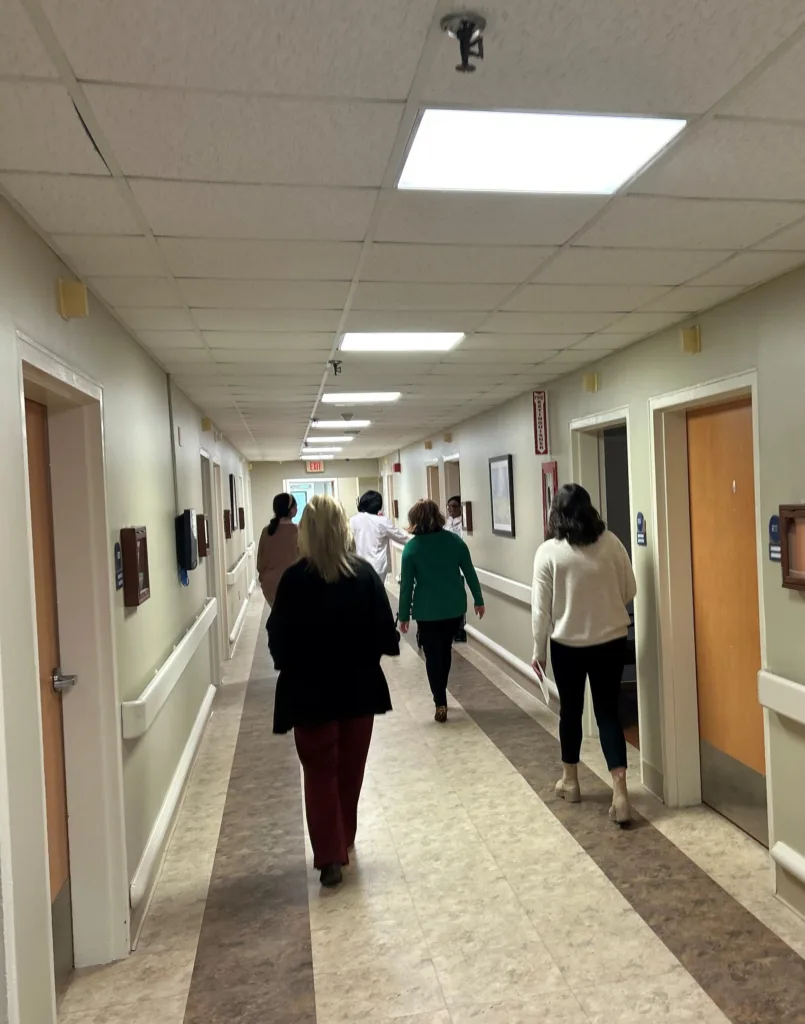 Event attendees walk along the updated corridor on the Memory Care Unit.